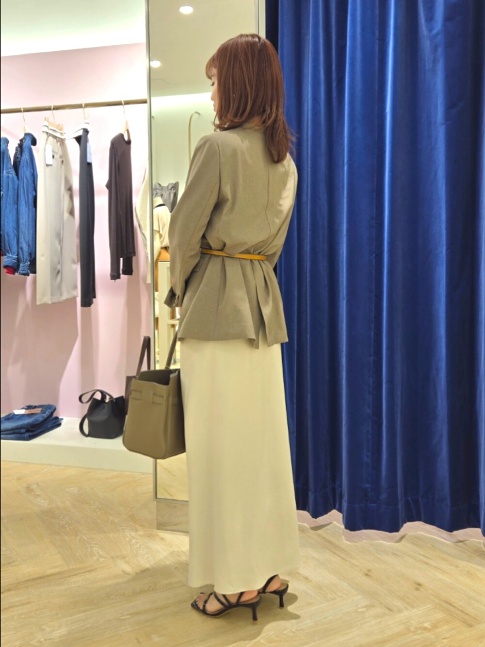 グリーン系のノーカラージャケット、ブラック系のタンクトップ、ベージュ系のトートバッグを着用したレディースの秋コーディネートの3枚目の写真