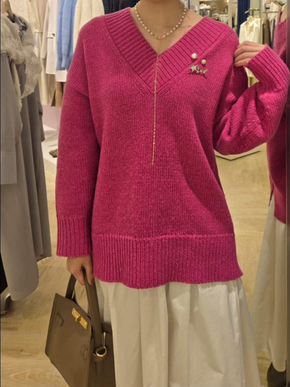 ホワイト系のスカート、ベージュ系のショルダーバッグ、ピンク系のニット/セーターを着用したレディースの秋コーディネートの4枚目の写真