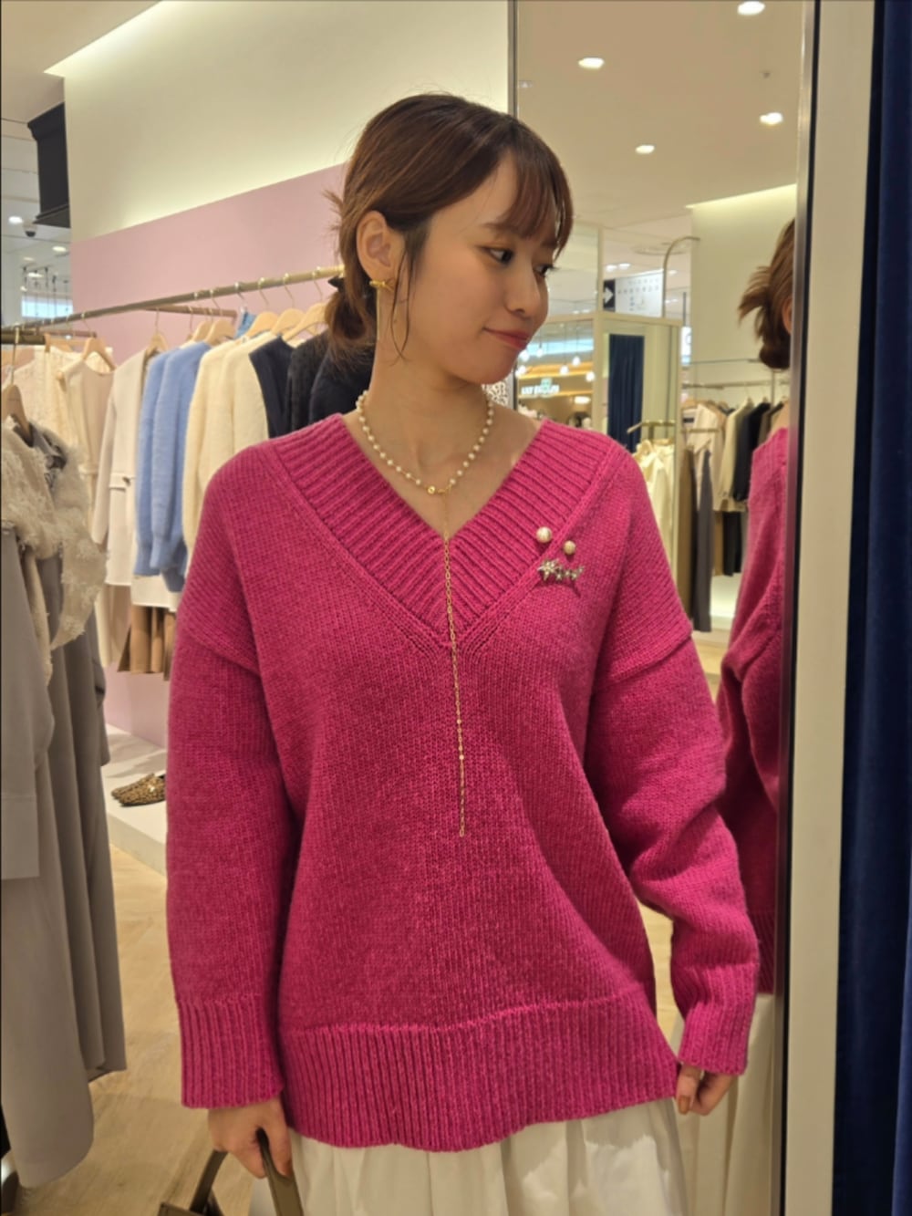 ホワイト系のスカート、ベージュ系のショルダーバッグ、ピンク系のニット/セーターを着用したレディースの秋コーディネートの3枚目の写真