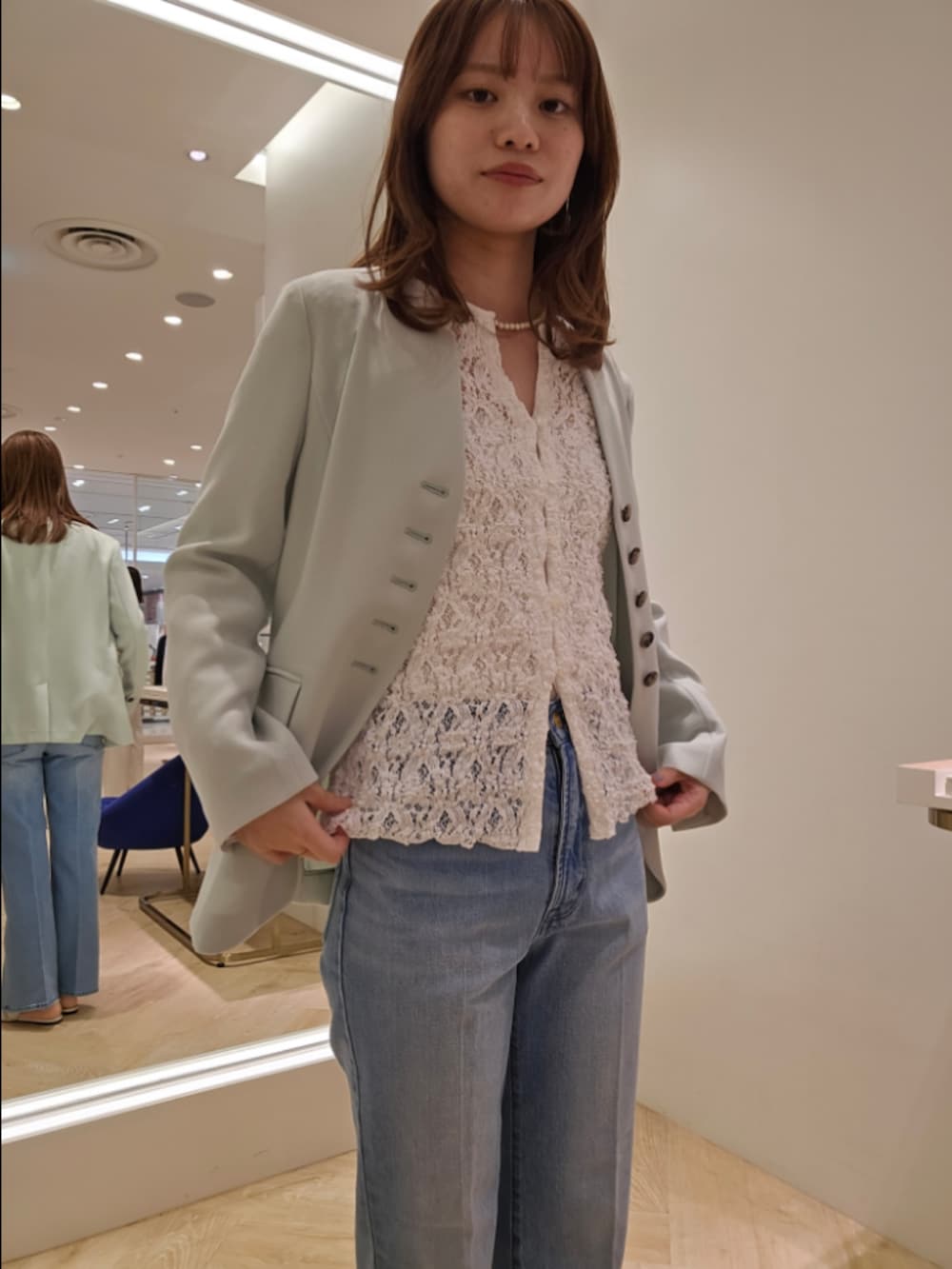 ブルー系のデニムパンツ、ホワイト系のカーディガン/ボレロ、グリーン系のノーカラージャケットを着用したレディースの冬コーディネートの7枚目の写真