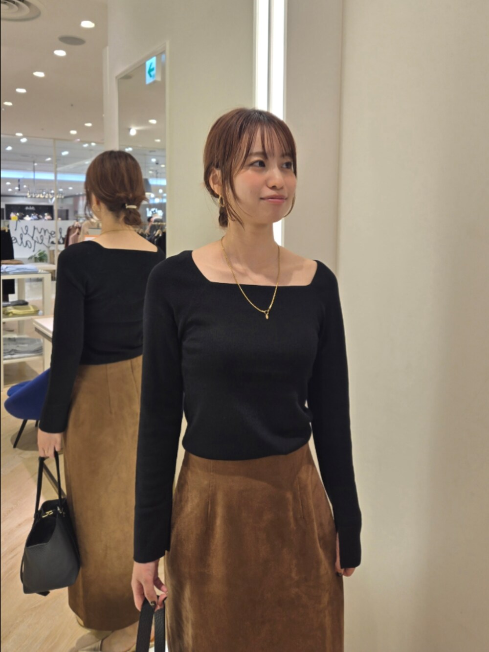 ブラウン系のスカート、ブラック系のニット/セーター、ブラック系のショルダーバッグを着用したレディースの秋コーディネートの7枚目の写真