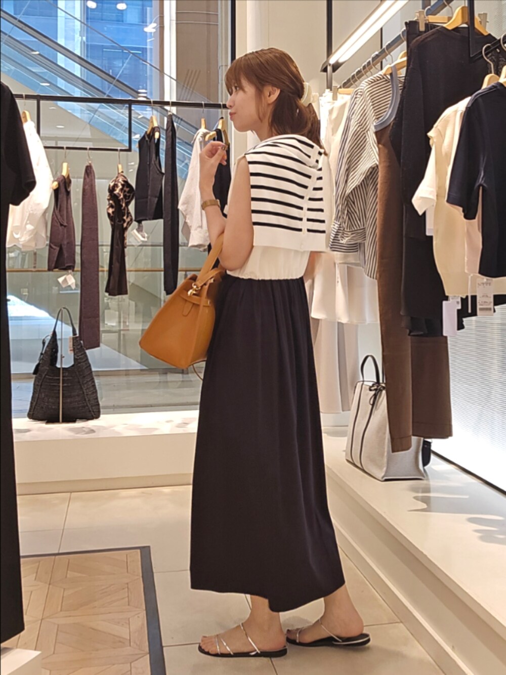 ホワイト系のカーディガン/ボレロ、ブラック系のワンピース、イエロー系のショルダーバッグを着用したレディースの夏コーディネートの2枚目の写真