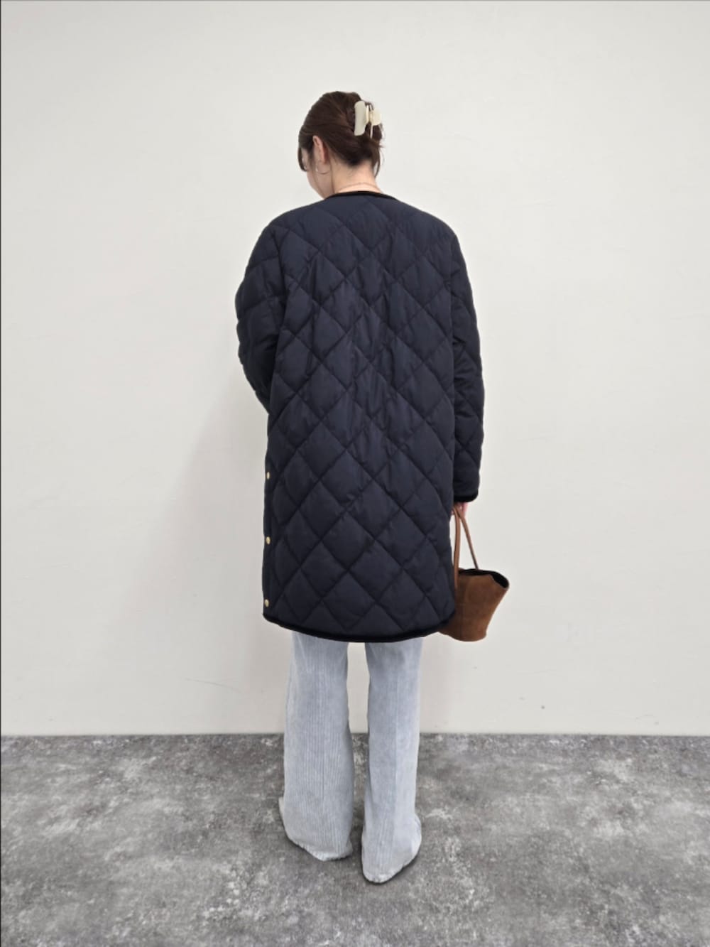 ブルー系のダウンジャケット/コート、ブラック系のTシャツ/カットソー、ブルー系のデニムパンツを着用したレディースの秋コーディネートの2枚目の写真