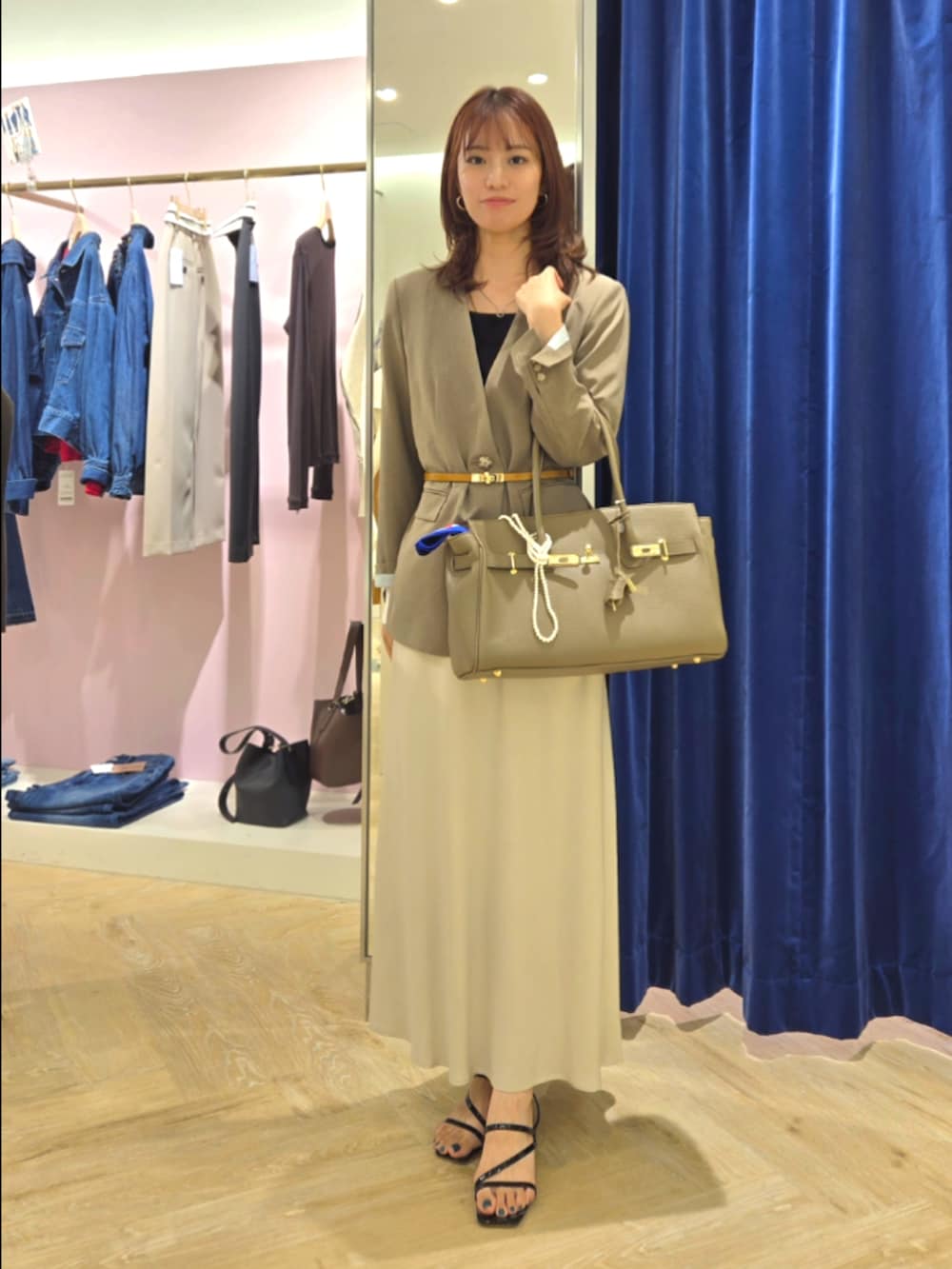 グリーン系のノーカラージャケット、ブラック系のタンクトップ、ベージュ系のトートバッグを着用したレディースの秋コーディネートの7枚目の写真