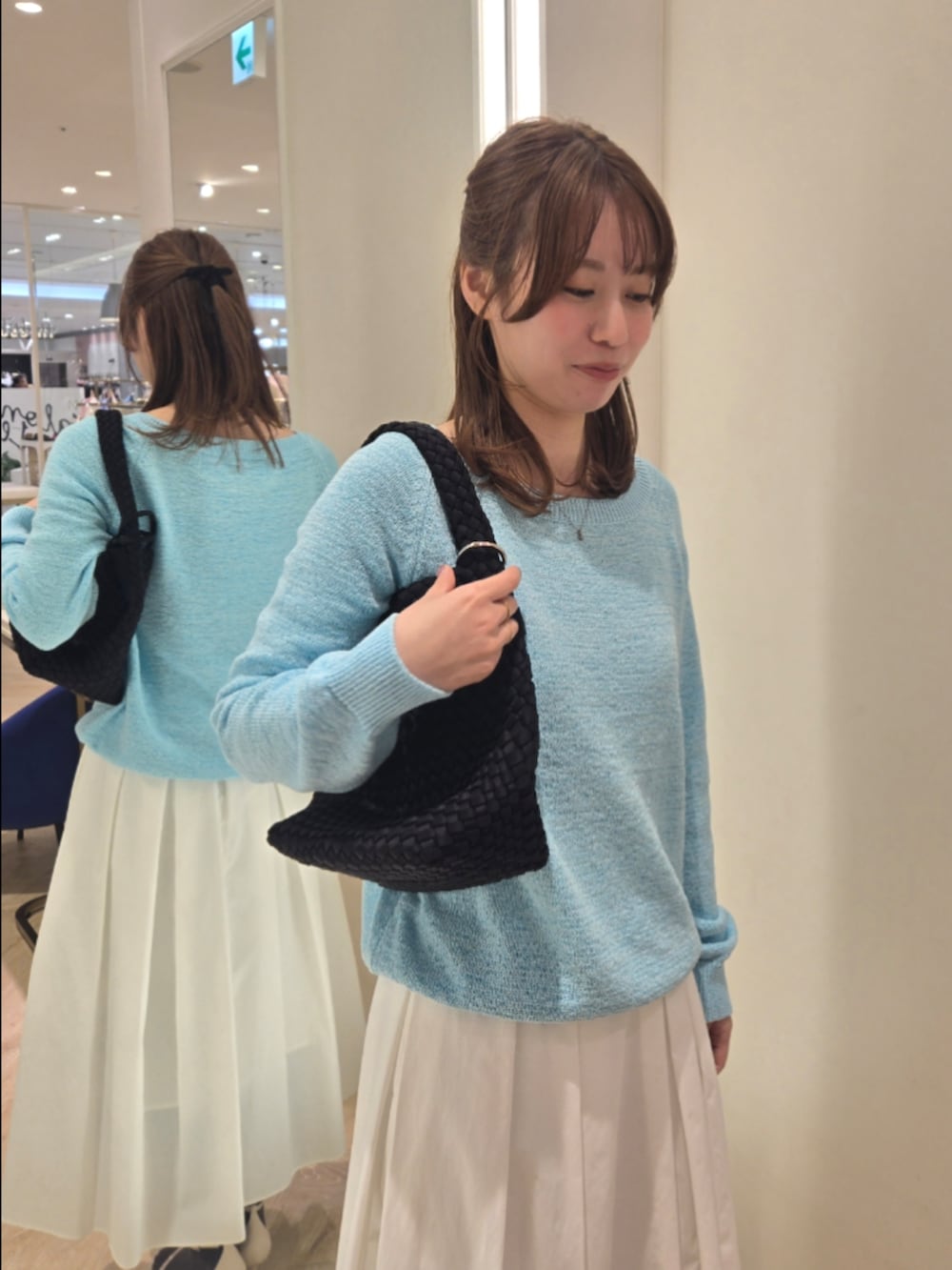 ホワイト系のスカート、ブルー系のニット/セーター、ブラック系のショルダーバッグを着用したレディースの春コーディネートの5枚目の写真