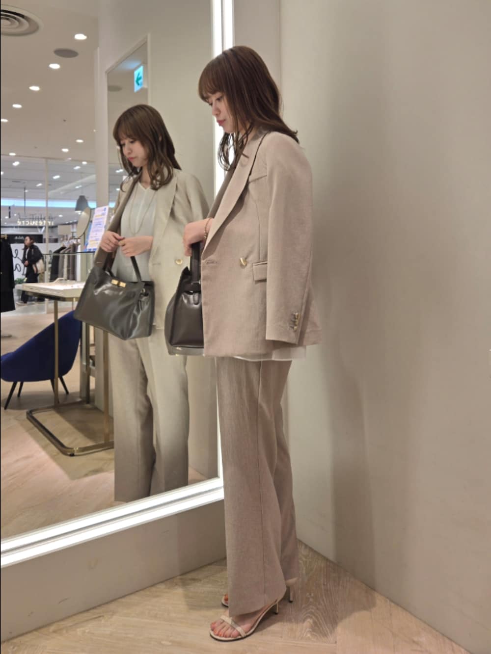 ベージュ系のテーラードジャケット、ベージュ系のその他パンツ、ホワイト系のシャツ/ブラウスを着用したレディースの春コーディネートの2枚目の写真