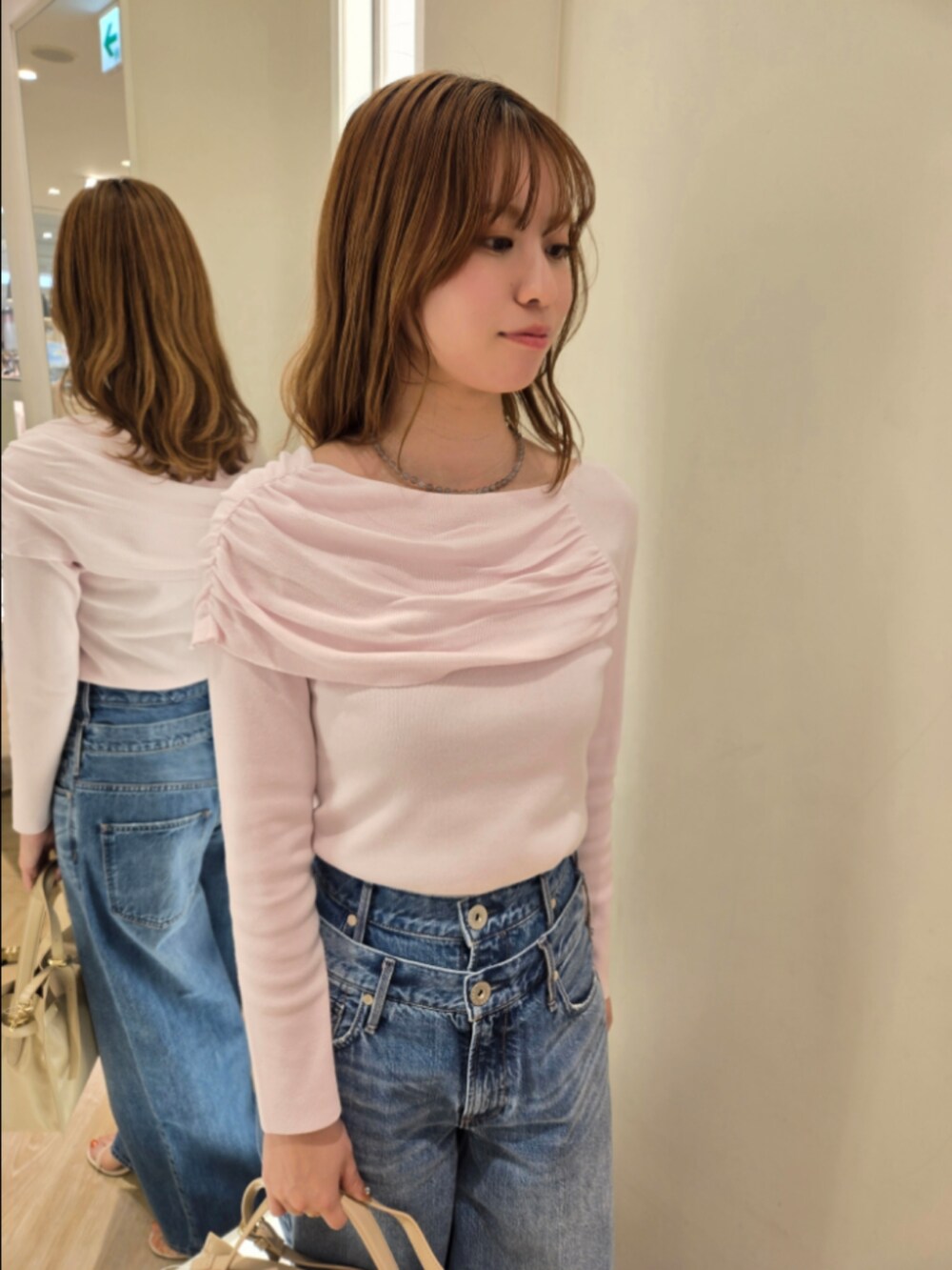 ピンク系のニット/セーター、ベージュ系のトートバッグ、グレー系のネックレスを着用したレディースの春コーディネートの6枚目の写真