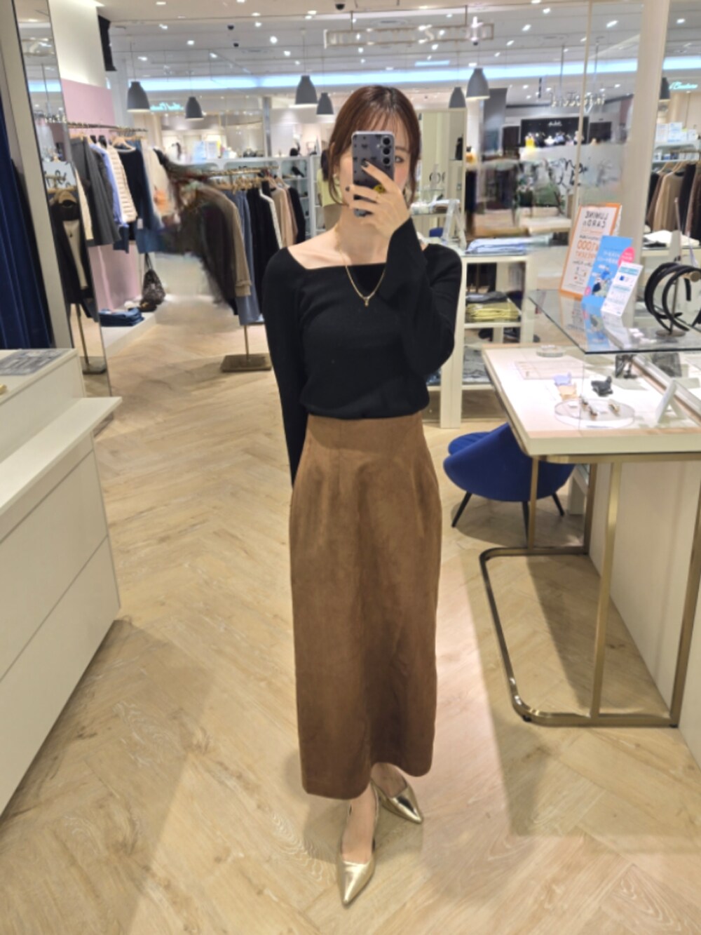 ブラウン系のスカート、ブラック系のニット/セーター、ブラック系のショルダーバッグを着用したレディースの秋コーディネートの9枚目の写真