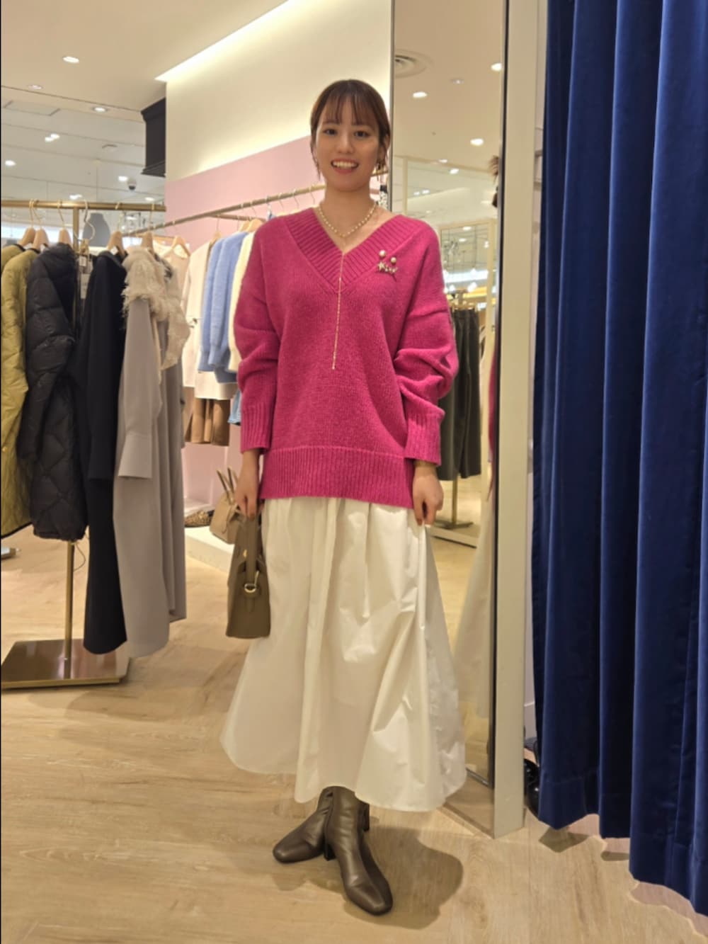 ホワイト系のスカート、ベージュ系のショルダーバッグ、ピンク系のニット/セーターを着用したレディースの秋コーディネートの6枚目の写真