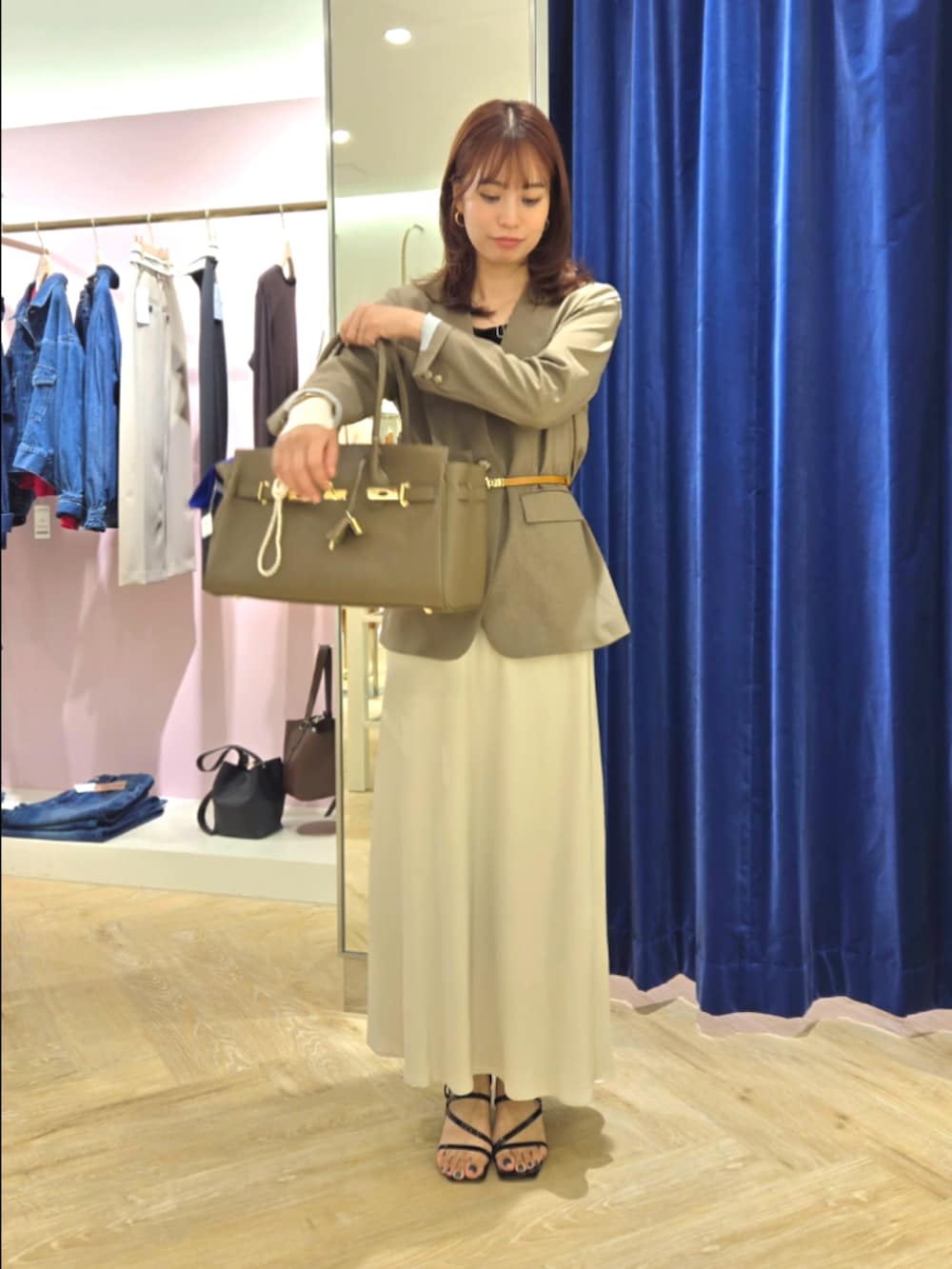 グリーン系のノーカラージャケット、ブラック系のタンクトップ、ベージュ系のトートバッグを着用したレディースの秋コーディネートの6枚目の写真