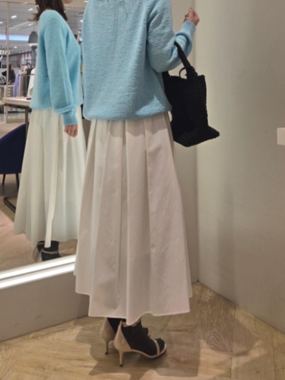 ホワイト系のスカート、ブルー系のニット/セーター、ブラック系のショルダーバッグを着用したレディースの春コーディネートの8枚目の写真