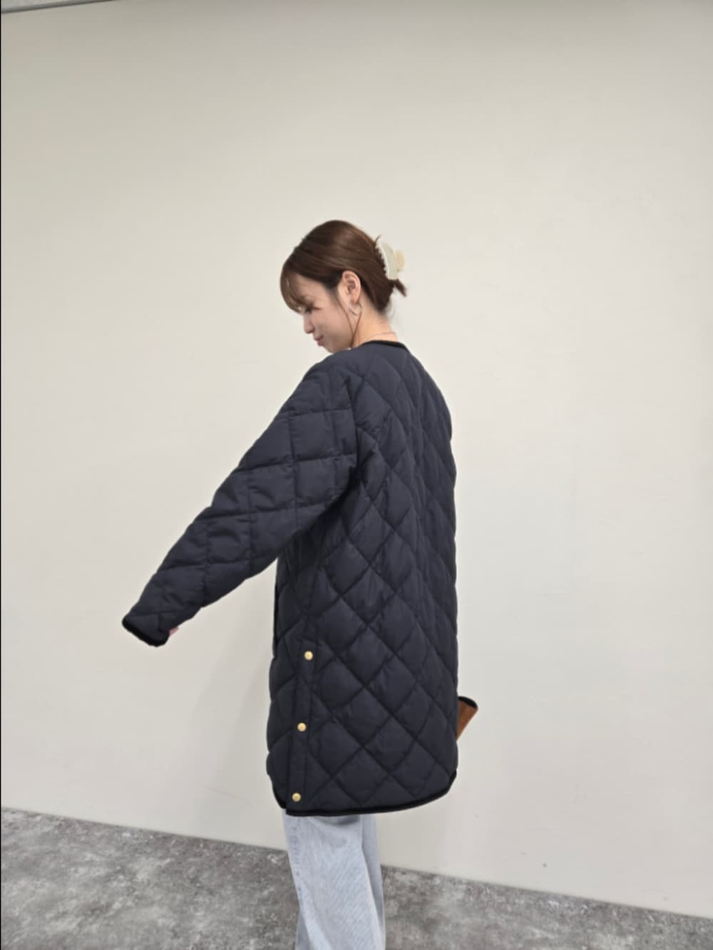 ブルー系のダウンジャケット/コート、ブラック系のTシャツ/カットソー、ブルー系のデニムパンツを着用したレディースの秋コーディネートの4枚目の写真