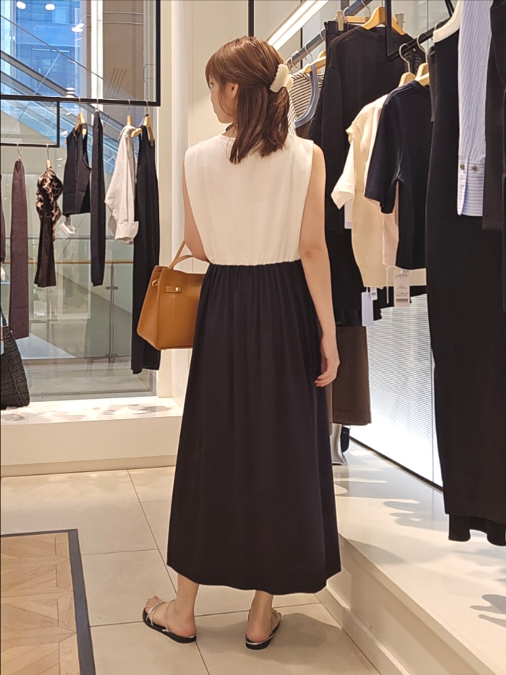 ホワイト系のカーディガン/ボレロ、ブラック系のワンピース、イエロー系のショルダーバッグを着用したレディースの夏コーディネートの3枚目の写真