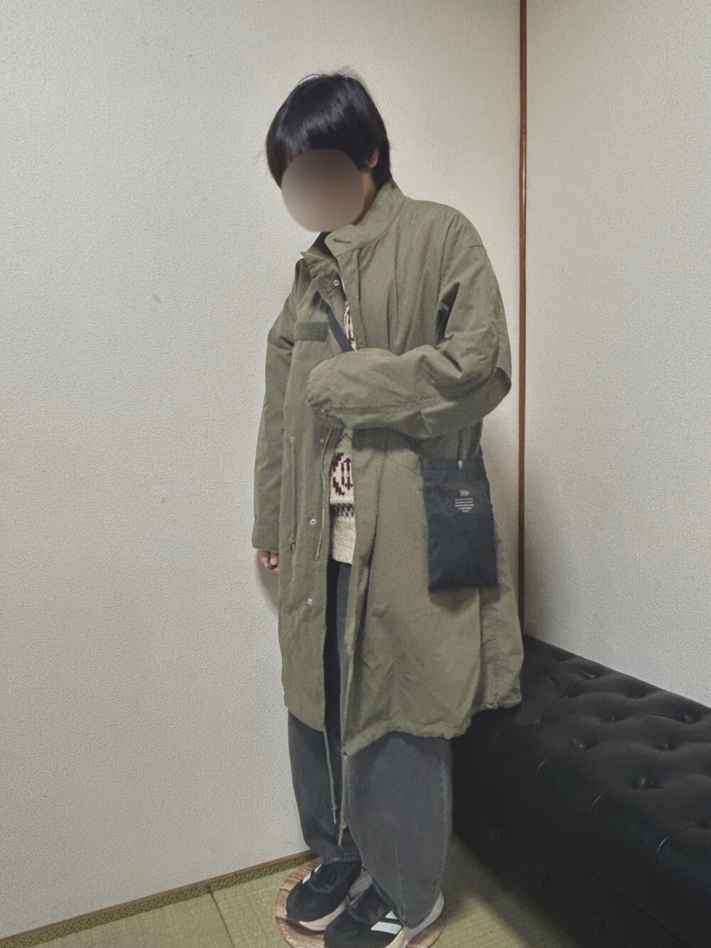 グレー系のデニムパンツ、ブラック系のショルダーバッグ、ホワイト系のニット/セーターを着用したレディースの冬コーディネートの2枚目の写真