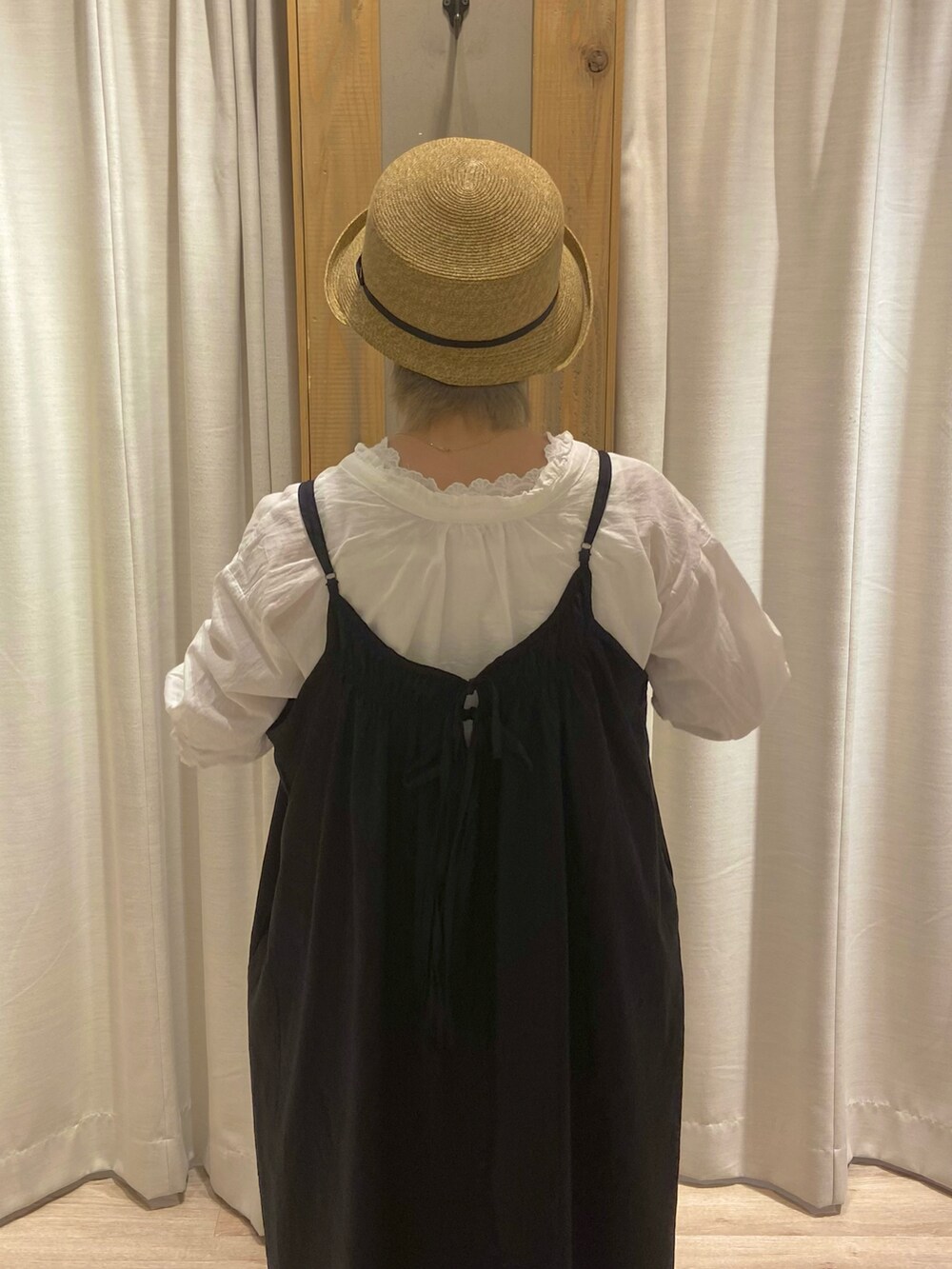 ホワイト系のシャツ/ブラウス、ホワイト系のTシャツ/カットソー、ブラック系のジャンパースカートを着用したレディースの春コーディネートの2枚目の写真