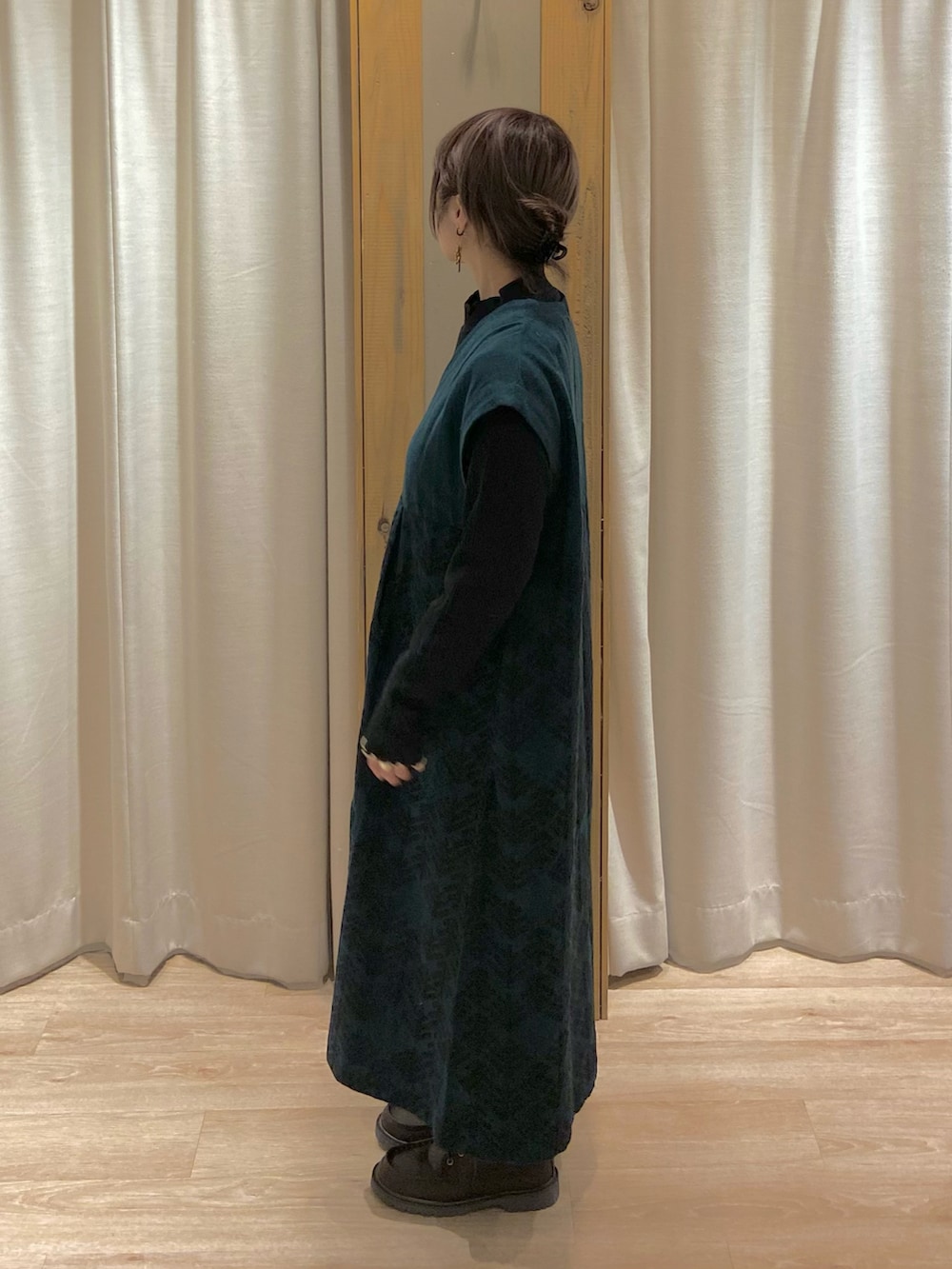 ベージュ系のカーディガン/ボレロ、グリーン系のワンピース、ブラウン系のブーツを着用したレディースの冬コーディネートの4枚目の写真