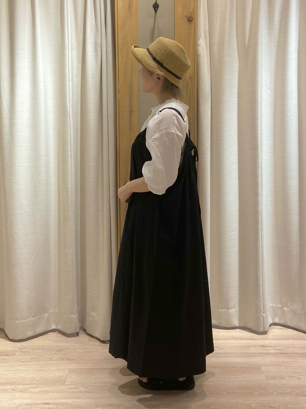 ホワイト系のシャツ/ブラウス、ホワイト系のTシャツ/カットソー、ブラック系のジャンパースカートを着用したレディースの春コーディネートの3枚目の写真