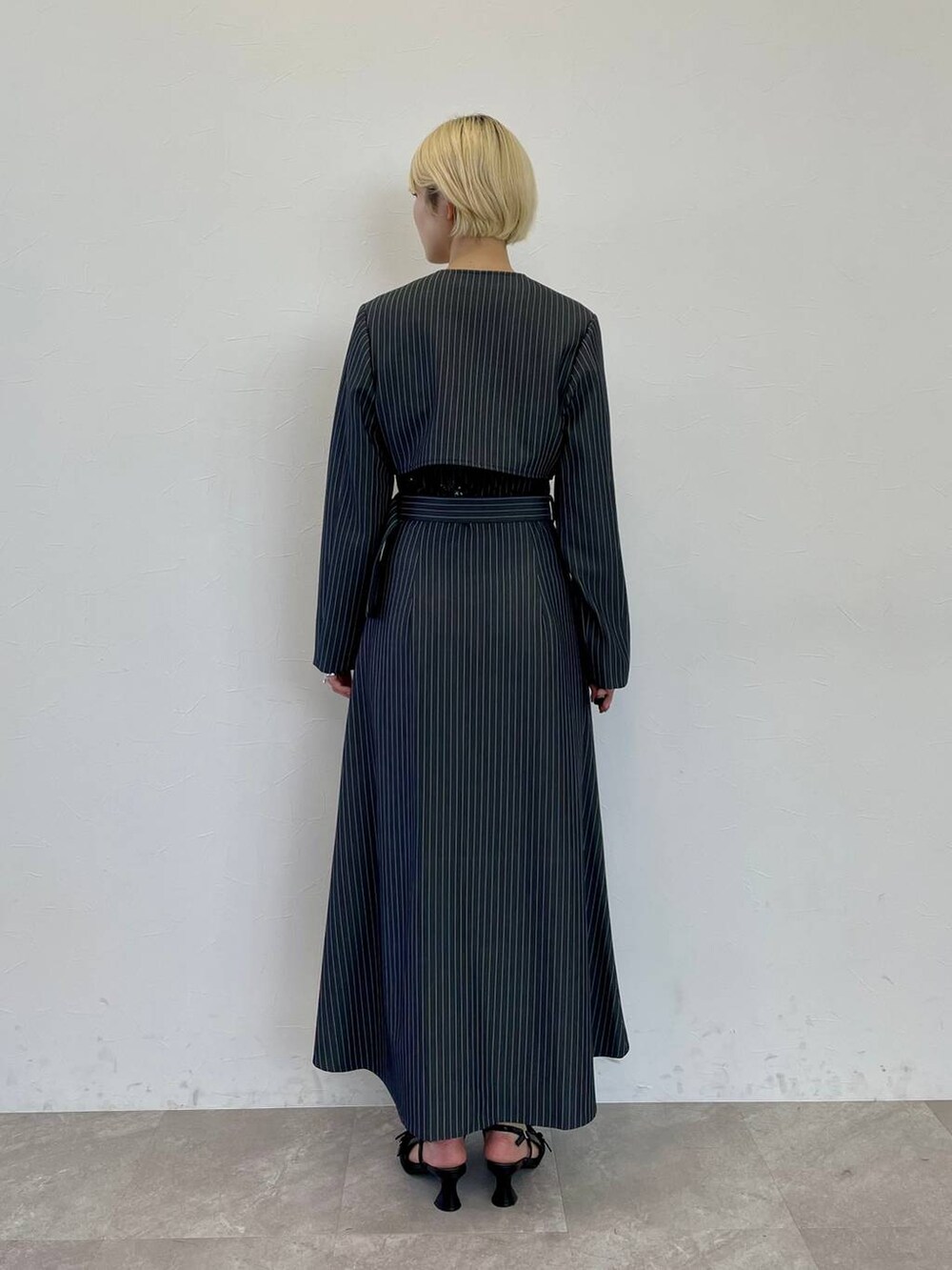 ブラック系のパンプス、ホワイト系のショルダーバッグ、その他のジャンパースカートを着用したレディースの夏コーディネートの3枚目の写真