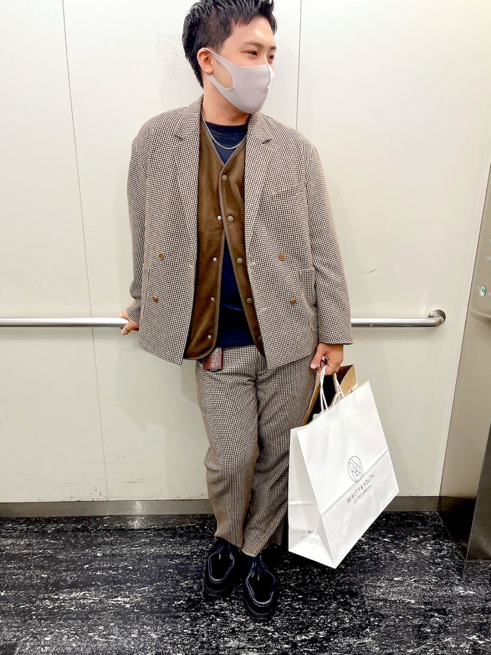 ブルー系のブーツ、ブラウン系のテーラードジャケット、ブラウン系のスラックスを着用したメンズの冬コーディネートの2枚目の写真