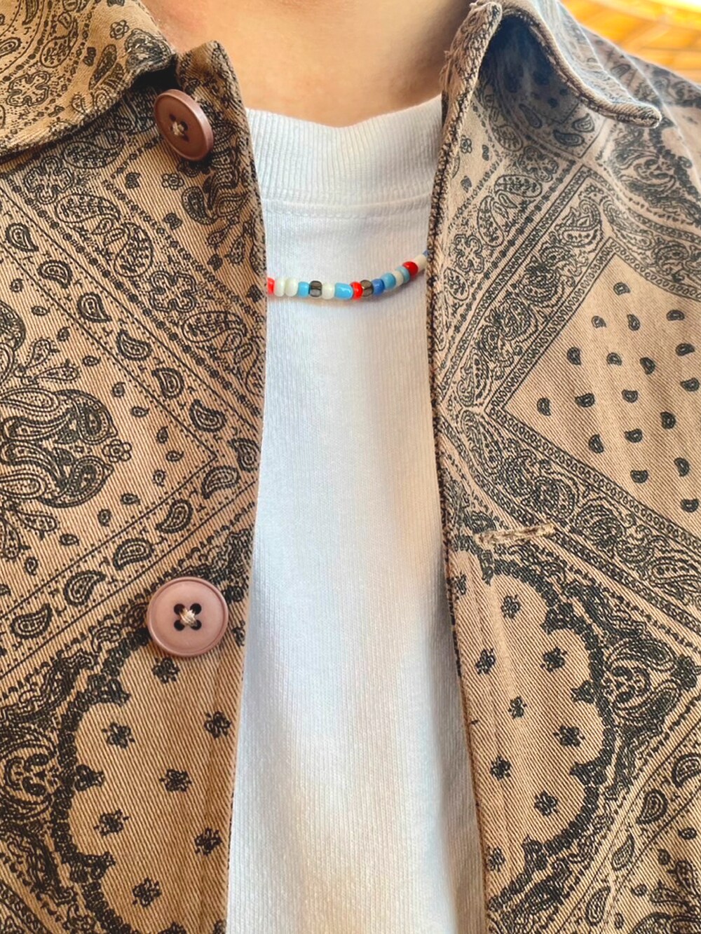 ブラウン系のジャケット/アウター、ホワイト系のTシャツ/カットソー、ブルー系のデニムパンツを着用したメンズの秋コーディネートの3枚目の写真