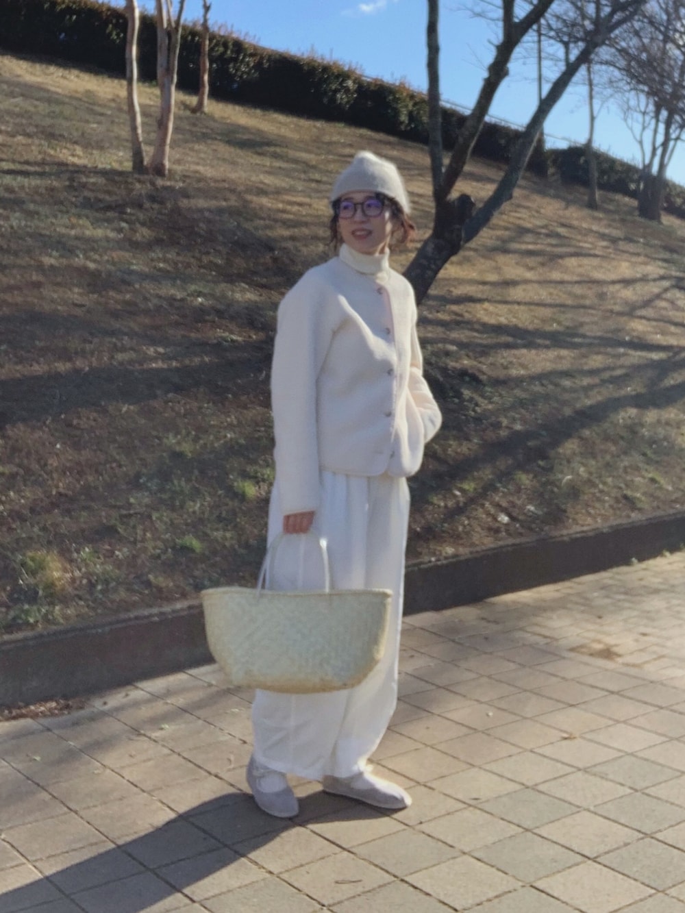 ベージュ系のかごバッグ、ホワイト系のノーカラージャケット、ホワイト系のその他パンツを着用したレディースの冬コーディネートの2枚目の写真