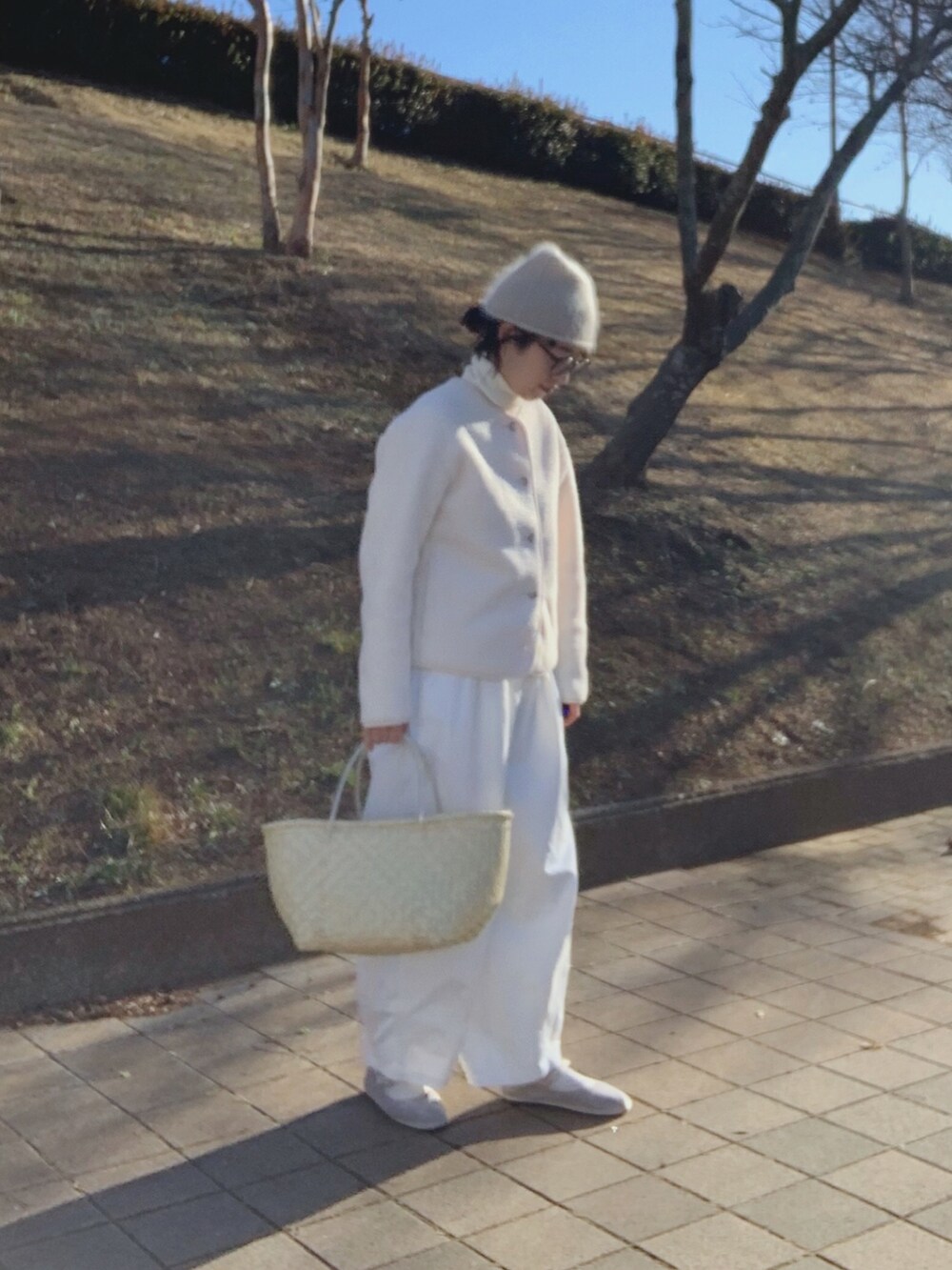 ベージュ系のかごバッグ、ホワイト系のノーカラージャケット、ホワイト系のその他パンツを着用したレディースの冬コーディネートの3枚目の写真