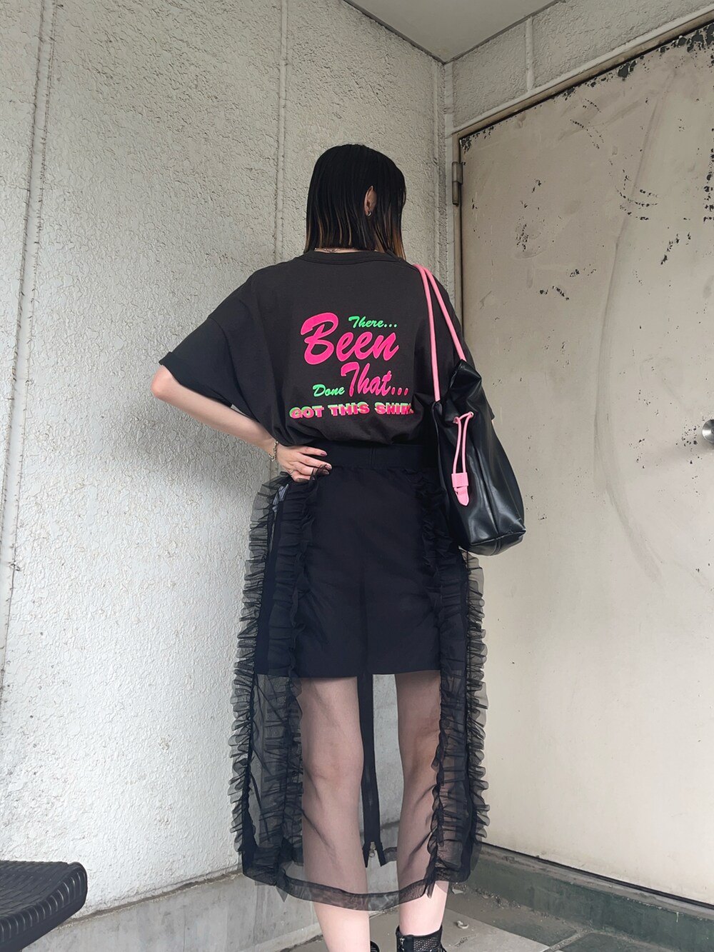 ブラック系のブーツ、ブラック系のTシャツ/カットソー、ブラック系のトートバッグを着用したレディースの夏コーディネートの2枚目の写真