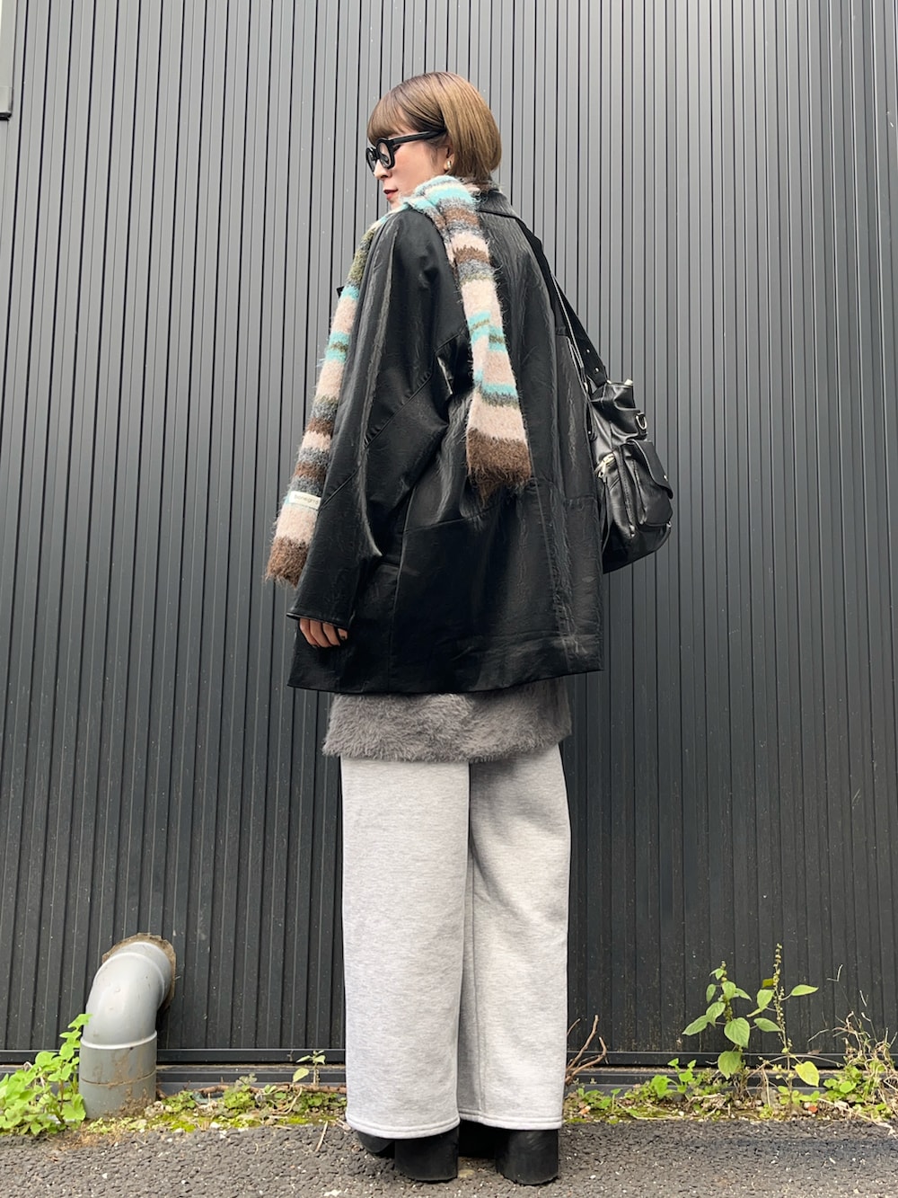 ブラック系のテーラードジャケット、グレー系のベスト、グレー系のスウェットパンツを着用したレディースの秋コーディネートの2枚目の写真