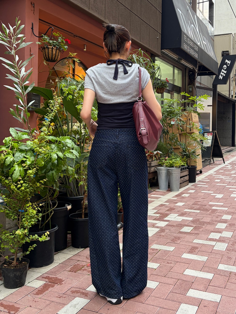 シルバー系のスニーカー、レッド系のショルダーバッグ、ブルー系のタンクトップを着用したレディースの夏コーディネートの2枚目の写真
