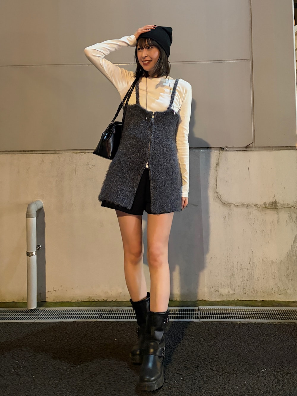 ブラック系のブーツ、ホワイト系のTシャツ/カットソー、ブラック系のショルダーバッグを着用したレディースの秋コーディネートの2枚目の写真