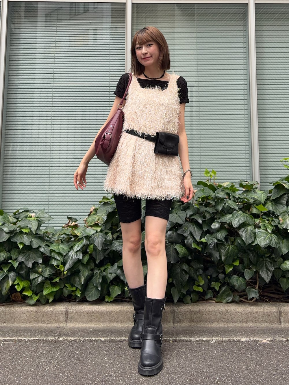 レッド系のショルダーバッグ、ブラック系のブーツ、ブラック系のTシャツ/カットソーを着用したレディースの秋コーディネートの2枚目の写真