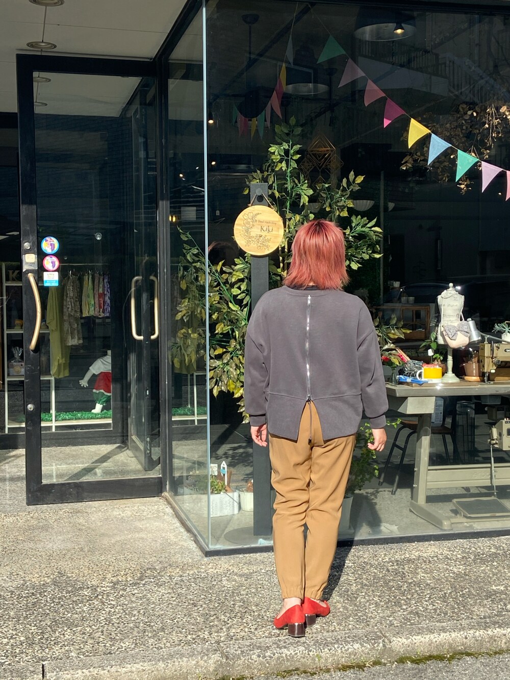 ベージュ系のチノパンツ、レッド系のパンプス、グレー系のスウェットを着用したレディースの春コーディネートの3枚目の写真