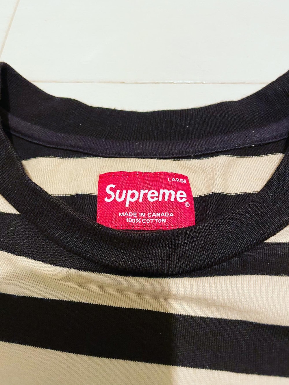 ブラウン系のTシャツ/カットソー、ホワイト系のスニーカー、ブラック系のネックレスを着用したメンズの夏コーディネートの3枚目の写真