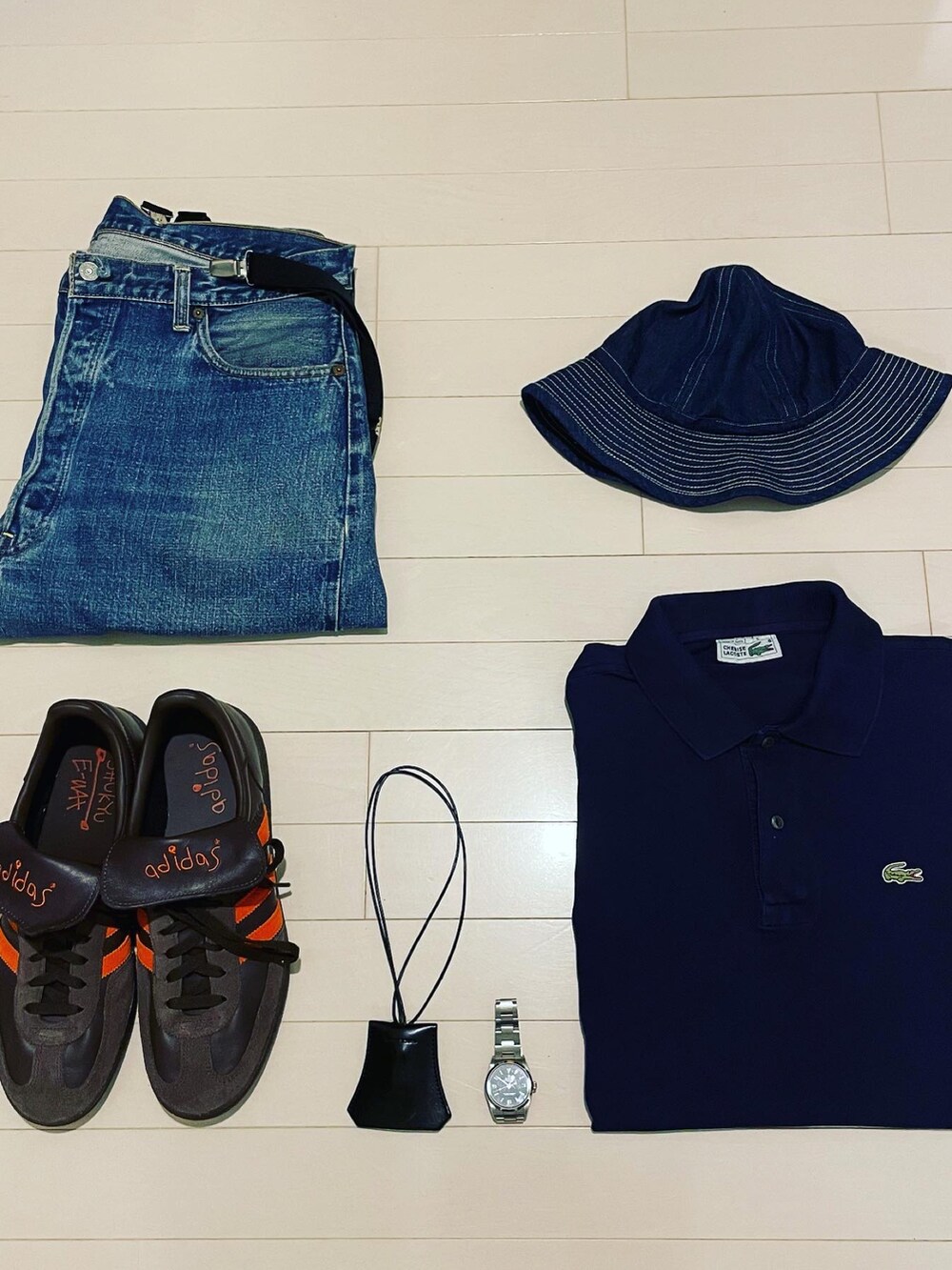 ブルー系のデニムパンツ、ブラウン系のスニーカー、ブルー系のポロシャツを着用したメンズの夏コーディネートの2枚目の写真