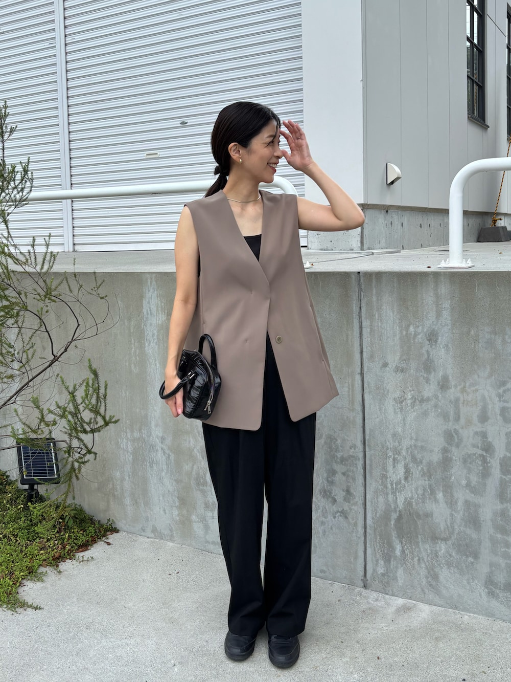 ブラウン系のその他アウター、ブラック系のスラックスを着用したレディースの秋コーディネートの2枚目の写真