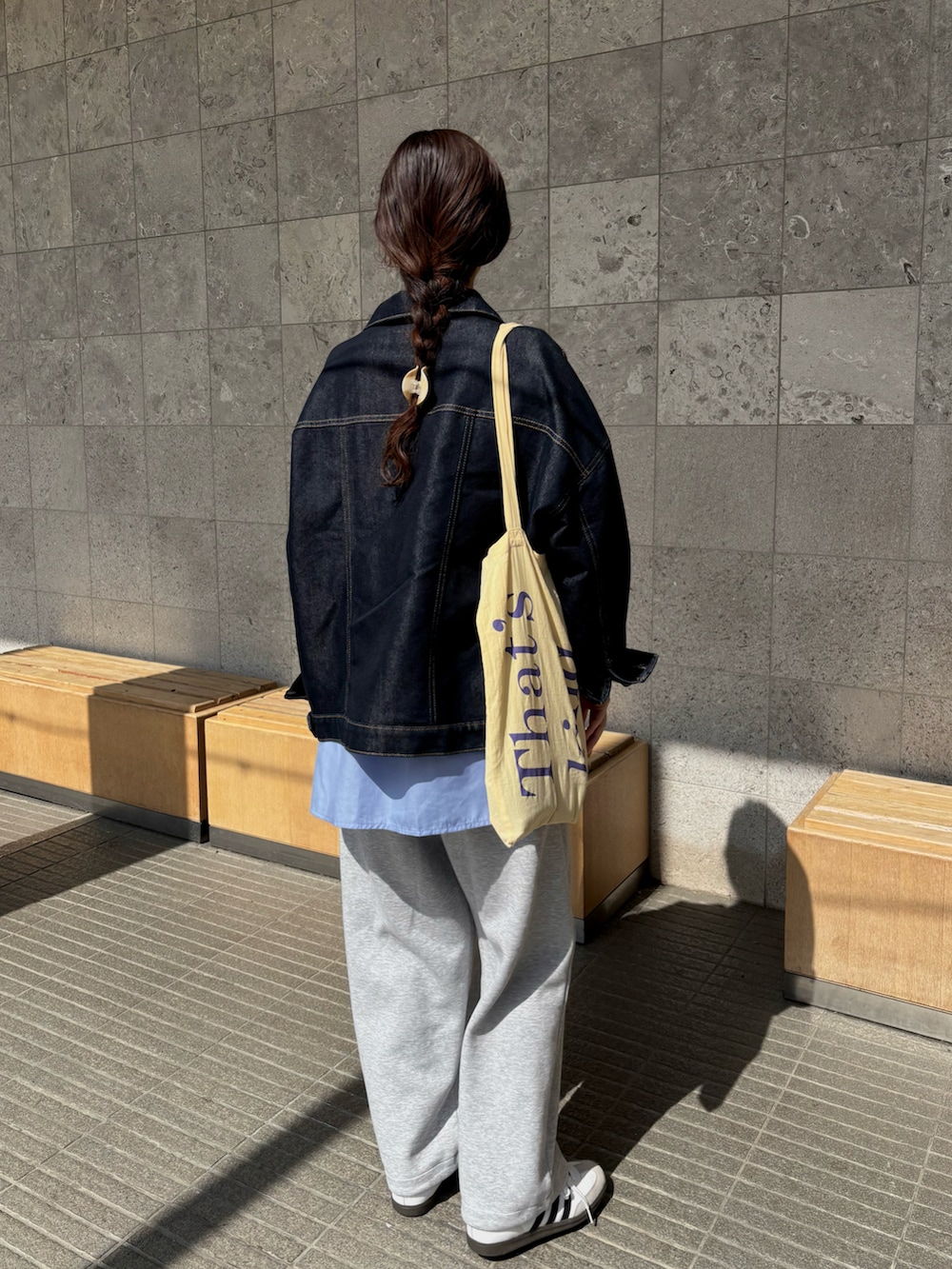 イエロー系のトートバッグ、ブルー系のシャツ/ブラウス、ブルー系のデニムジャケットを着用したレディースの春コーディネートの2枚目の写真