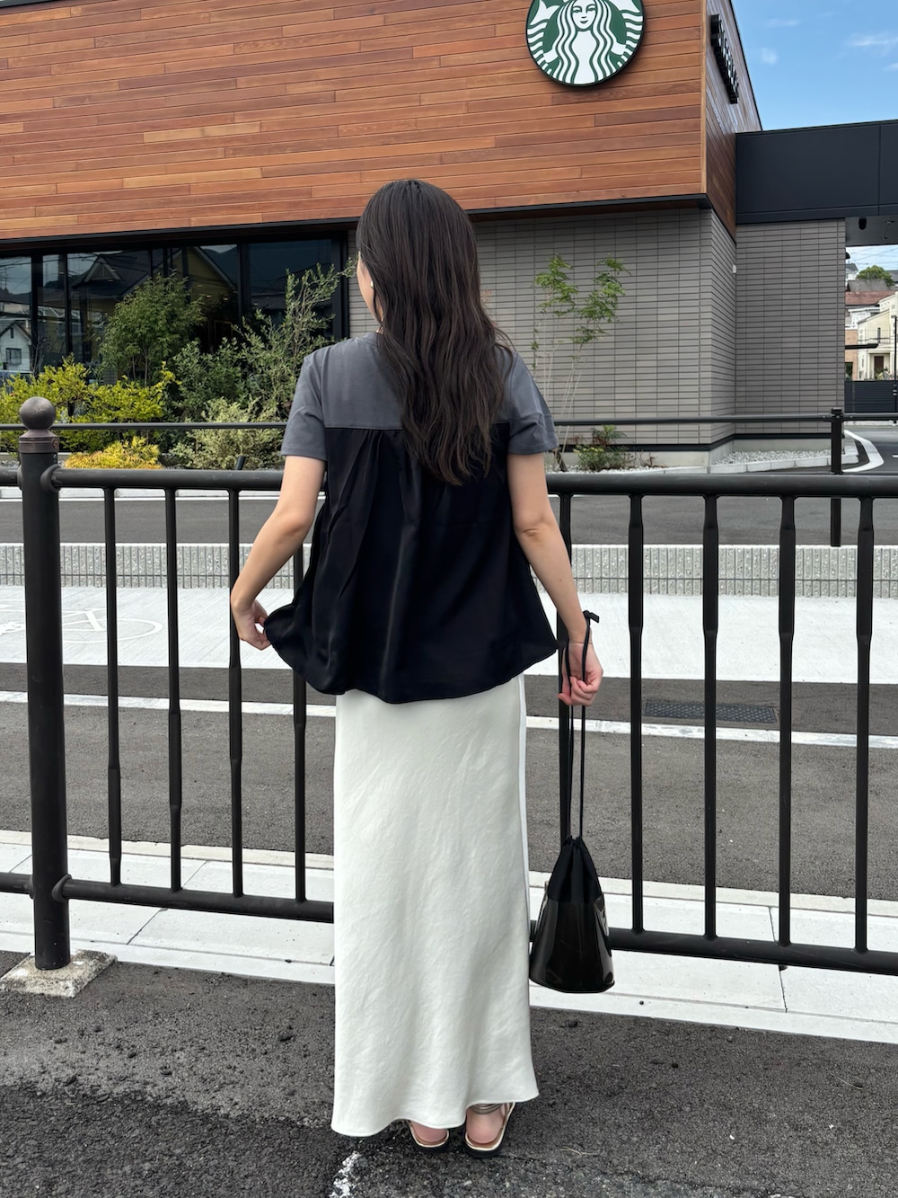 ホワイト系のスカート、グレー系のTシャツ/カットソーを着用したレディースの夏コーディネートの3枚目の写真