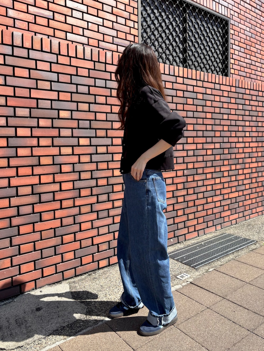 ブルー系のスニーカー、ブルー系のデニムパンツを着用したレディースの秋コーディネートの2枚目の写真
