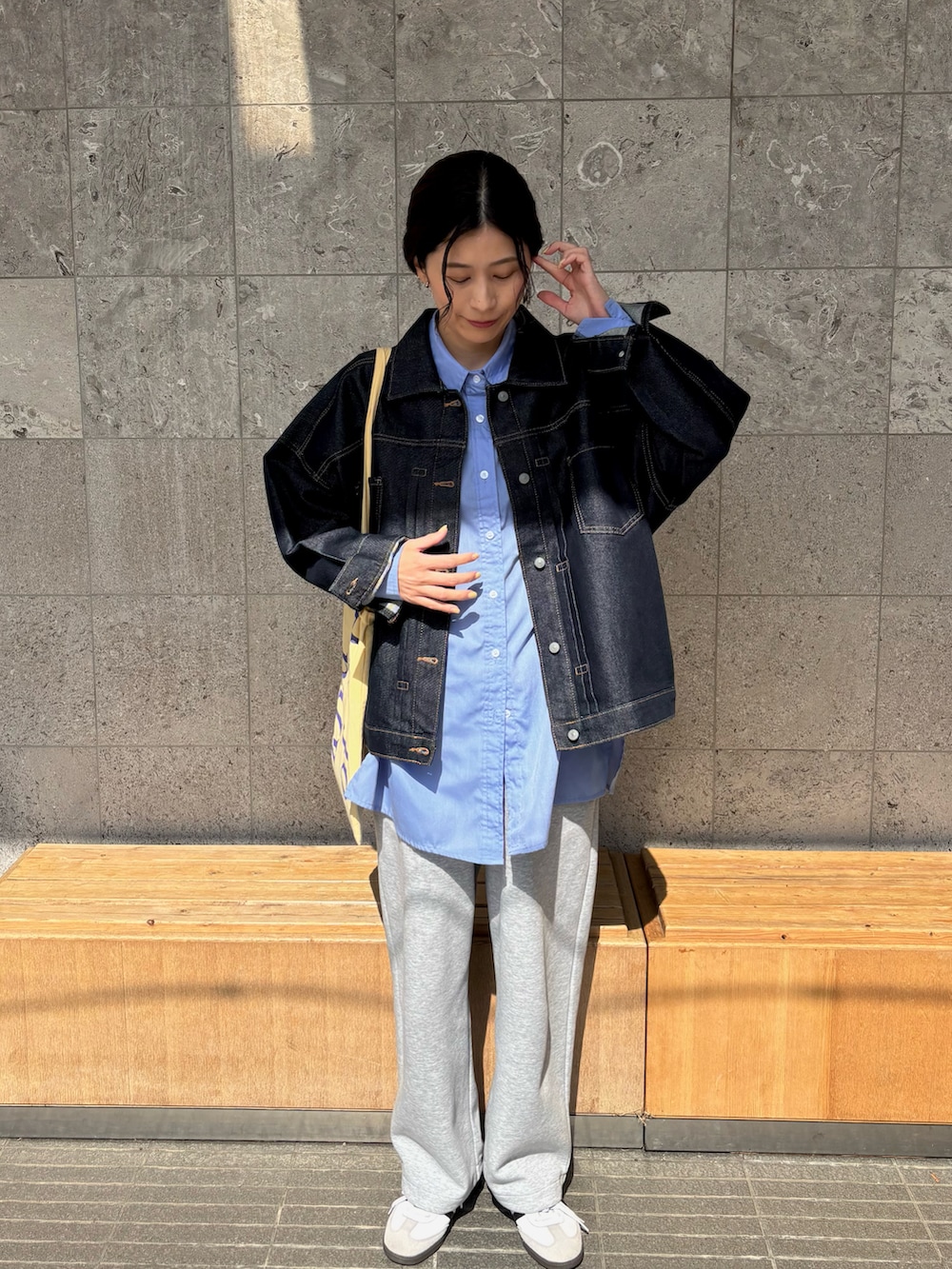 イエロー系のトートバッグ、ブルー系のシャツ/ブラウス、ブルー系のデニムジャケットを着用したレディースの春コーディネートの3枚目の写真