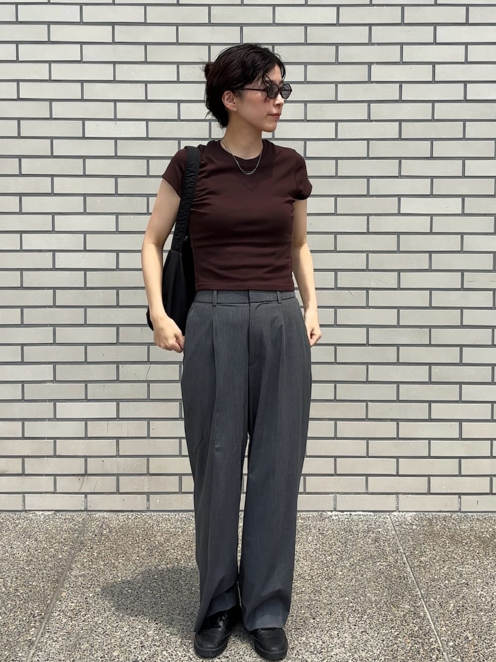 ブラウン系のTシャツ/カットソー、グレー系のスラックス、シルバー系のネックレスを着用したレディースの夏コーディネートの2枚目の写真