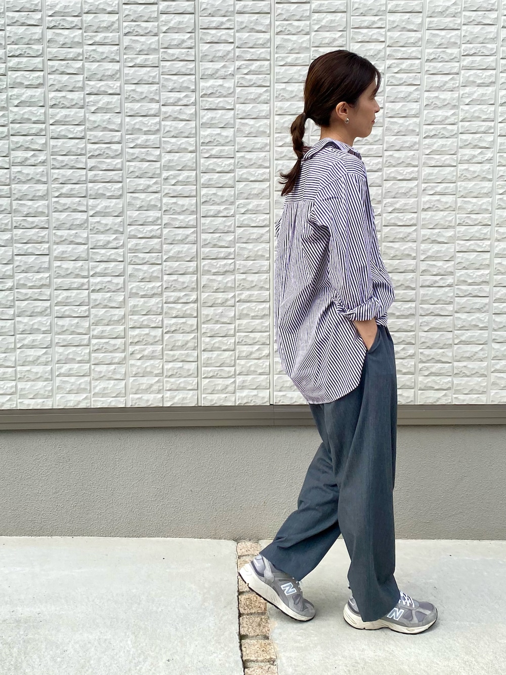 ブラウン系のシャツ/ブラウス、グレー系のスラックス、グレー系のスニーカーを着用したレディースの秋コーディネートの2枚目の写真