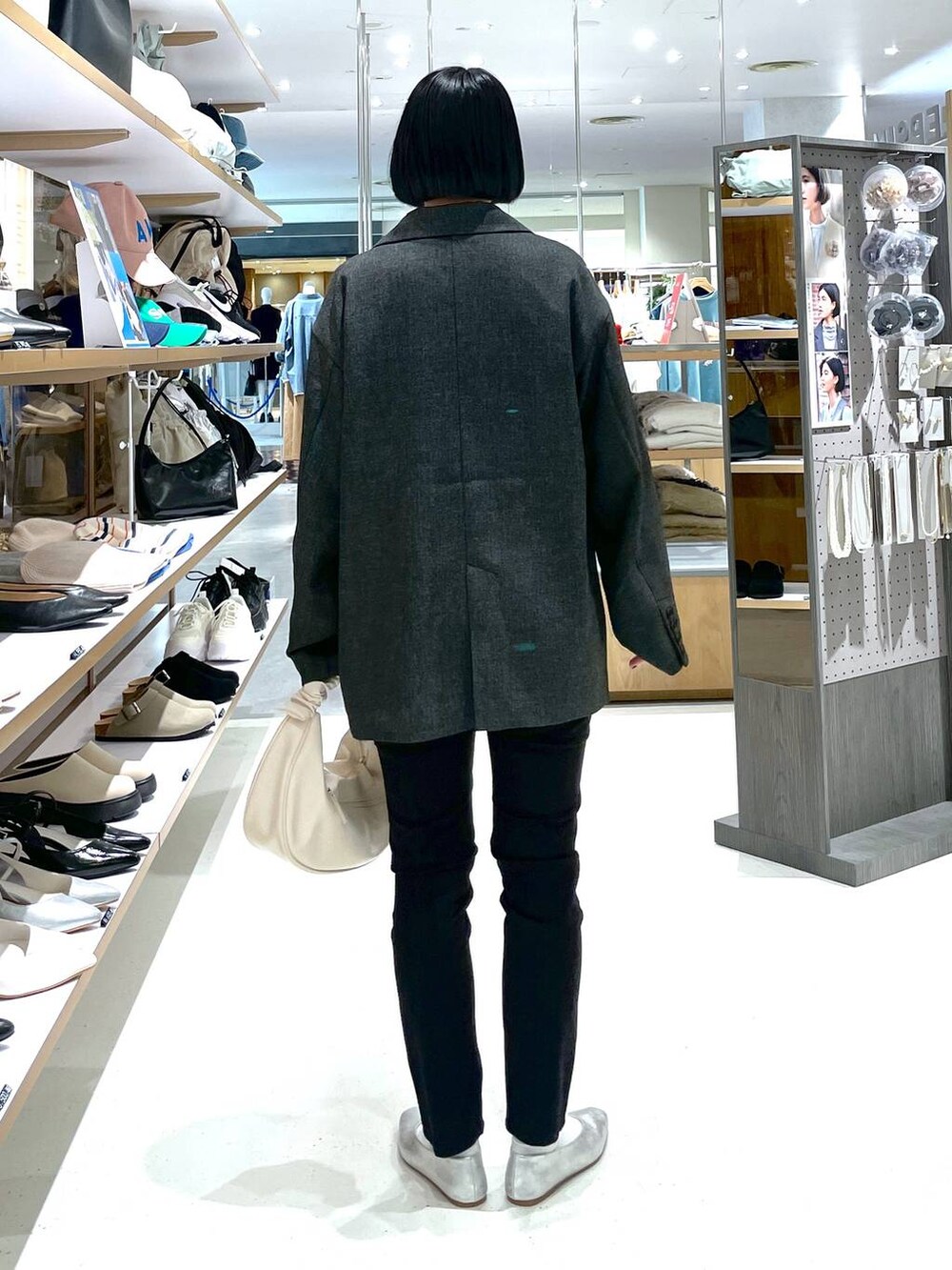 ホワイト系のショルダーバッグ、グレー系のパンプス、ブラック系のその他パンツを着用したレディースの冬コーディネートの4枚目の写真