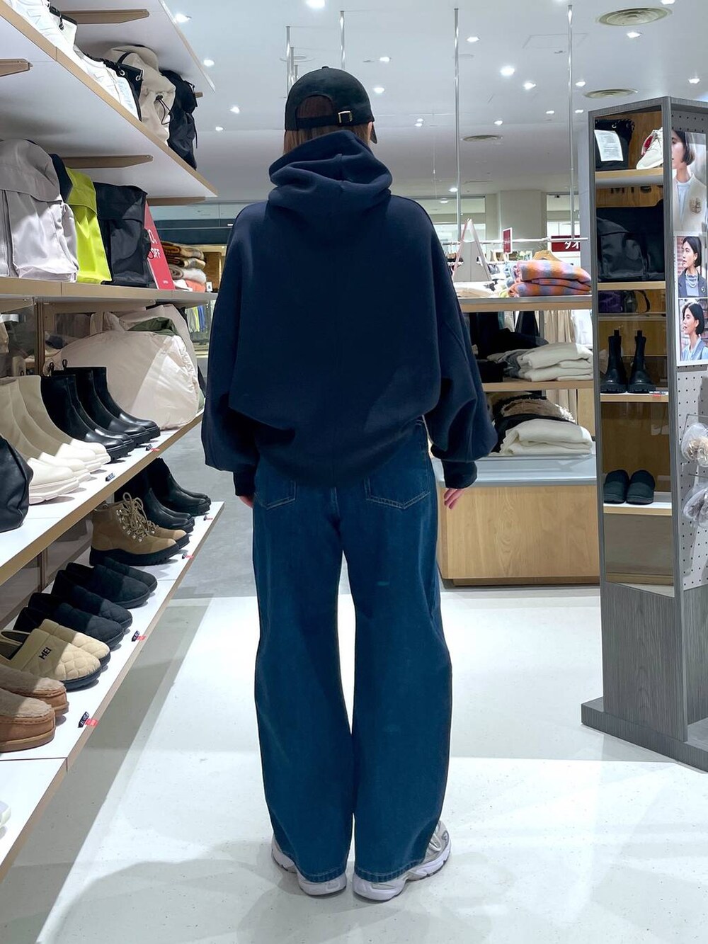 ブルー系のパーカー、ブルー系のデニムパンツ、ブラック系のキャップを着用したレディースの冬コーディネートの5枚目の写真