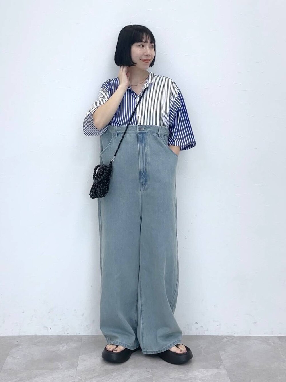 ブラック系のショルダーバッグを着用したレディースの夏コーディネートの2枚目の写真