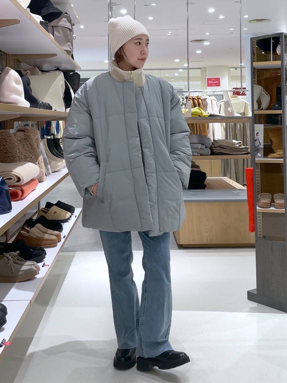 ホワイト系のニット/セーター、ブルー系のその他アウター、ブルー系のデニムパンツを着用したレディースの冬コーディネートの2枚目の写真