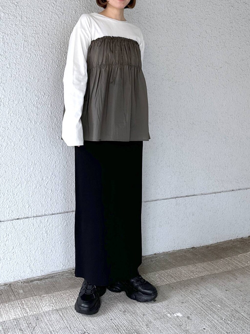 グリーン系のTシャツ/カットソー、ブラック系のスカートを着用したレディースの春コーディネートの4枚目の写真