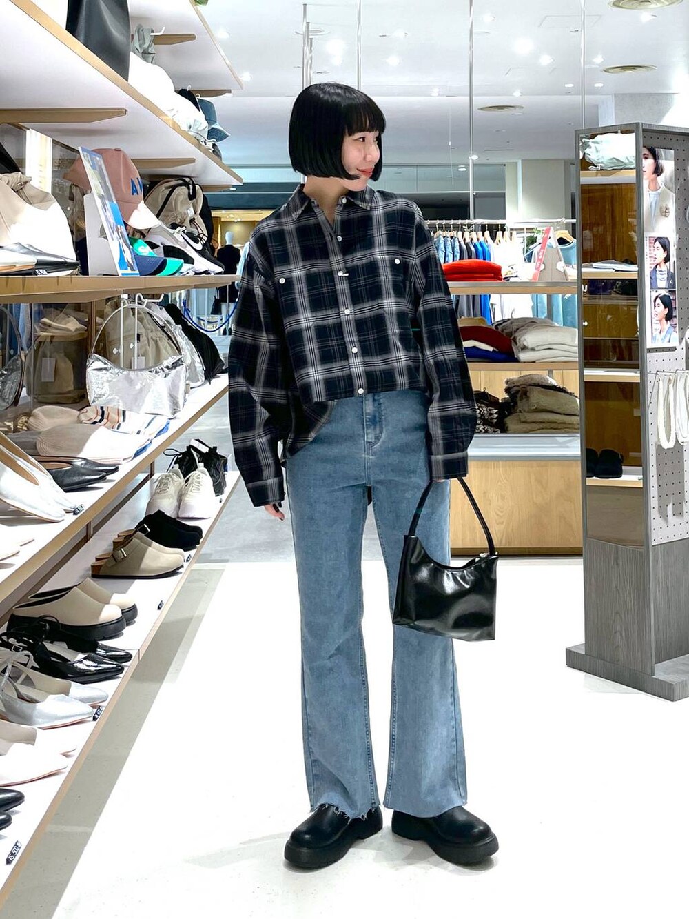 ブラック系のハンドバッグ、ブルー系のデニムパンツ、ブラック系のシャツ/ブラウスを着用したレディースの冬コーディネートの3枚目の写真