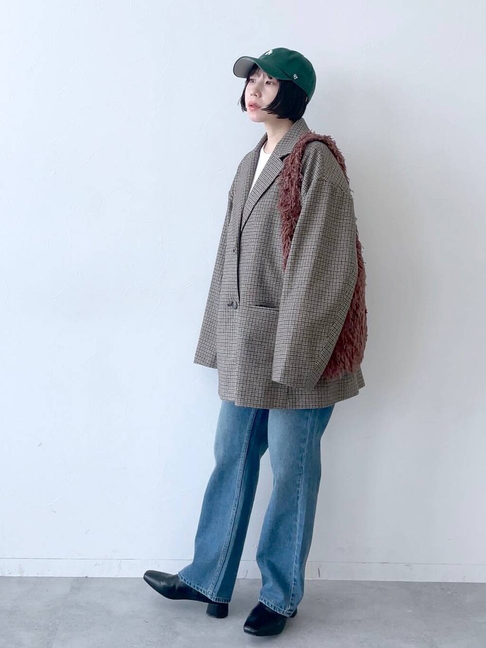 ブラウン系のその他アウター、ブルー系のデニムパンツ、ブラック系のブーツを着用したレディースの秋コーディネートの4枚目の写真