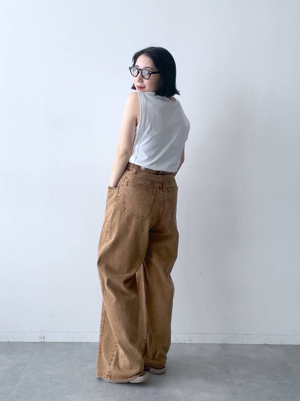 ブラウン系のデニムパンツを着用したレディースの夏コーディネートの4枚目の写真