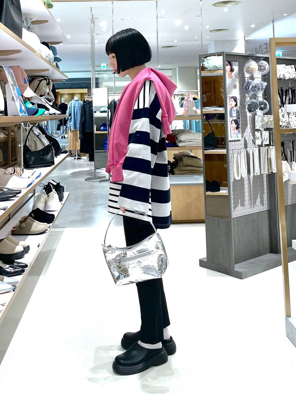 シルバー系のハンドバッグ、ブラック系のその他パンツ、ピンク系のTシャツ/カットソーを着用したレディースの冬コーディネートの3枚目の写真